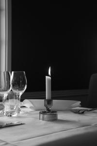 a candle sitting on top of a table with glasses at Åhus Gästgivaregård in Åhus