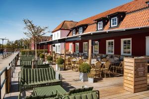 a row of chairs and tables on a wooden deck at Åhus Gästgivaregård in Åhus