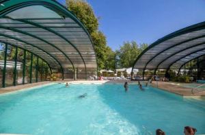 a swimming pool with people in the water at ZEcamping 4 étoiles chiens acceptés bien-être piscine couverte in Azur +68 photos
