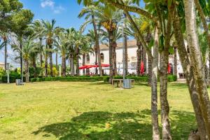 a park with palm trees in front of a building at Atlantico - Golf And Sun Holiday in Murcia