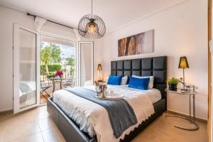 a bedroom with a large bed with blue pillows at Atlantico - Golf And Sun Holiday in Murcia +34 photos