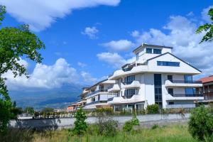 ein weißes Apartmenthaus mit blauem Himmel im Hintergrund in der Unterkunft Appartamento - Brand New Luxury Apartment - Giardini Naxos, Recanati in Giardini-Naxos