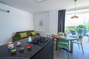 eine Küche und ein Wohnzimmer mit einem Herd und einem Tisch in der Unterkunft Appartamento - Brand New Luxury Apartment - Giardini Naxos, Recanati in Giardini-Naxos + 14 Fotos
