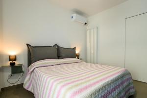 ein Schlafzimmer mit einem Bett mit einer gestreiften Decke in der Unterkunft Appartamento - Brand New Luxury Apartment - Giardini Naxos, Recanati in Giardini-Naxos