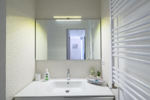 ein Badezimmer mit Waschbecken und Spiegel in der Unterkunft Appartamento - Brand New Luxury Apartment - Giardini Naxos, Recanati in Giardini-Naxos