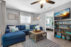 a living room with a blue couch and a tv at Rising Sun in Pensacola Beach