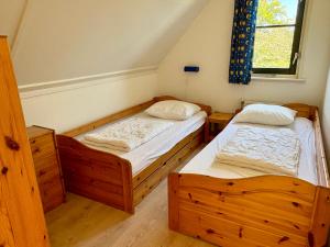two twin beds in a room with a window at Buitenplaats 105 in Callantsoog