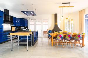 a kitchen with blue cabinets and a table with chairs at Villa Nico - By Aloha Palma in Águilas