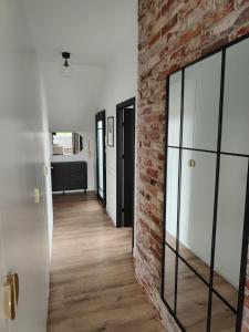 a room with a brick wall and a hallway at Apartament Jak w banku II in Kłodzko +21 photos