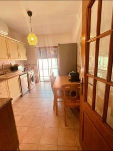 a kitchen with a table and a dining room at Elegant Getaway II - Lisbon- two bedroom apartment in Montijo- 10 mints from the beach in Atalaia