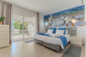 a bedroom with a bed with a painting on the wall at Villa Blanca in Callao Salvaje +78 photos