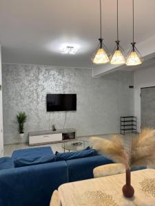 ein Wohnzimmer mit einer blauen Couch und einem Fernseher in der Unterkunft Blue Apartment in Năvodari