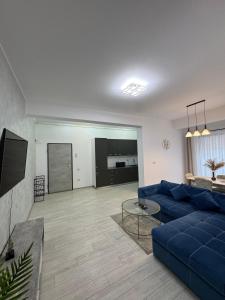 ein Wohnzimmer mit einer blauen Couch und einem Fernseher in der Unterkunft Blue Apartment in Năvodari