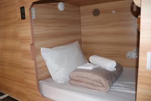 a room with a bed with towels and a pillow at SOPO Backpackers in Gold Coast