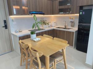a kitchen with a wooden table with chairs and a sink at Nothingness House in Thôn Văn Dương