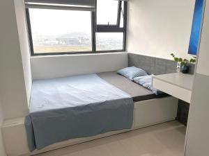 a bed in a small room with a window at Nothingness House in Thôn Văn Dương