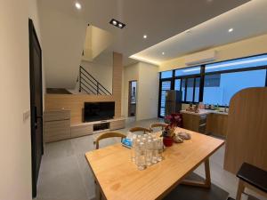 a dining room and kitchen with a wooden table and chairs at Anbys house in Yuanshan
