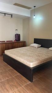 a large bed in a room with a suitcase at Serene Japandi Ryokan - Green Staycay in Jakarta in Jakarta