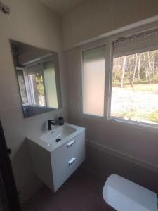 a bathroom with a sink and a mirror and a toilet at Chalet Lanzada in Sanxenxo +25 photos