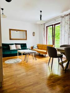 una sala de estar con un sofá y una mesa en Pohulanka Old City - parking & balcony, en Gdansk