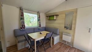 Camping les Mancellieres في Avrillé: غرفة طعام صغيرة مع طاولة وكراسي