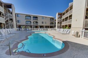una piscina en el patio de un edificio de apartamentos en Las Palmas 118 - The Sandy Palm, en Gulf Shores