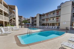 una piscina en el patio de un complejo de apartamentos en Las Palmas 118 - The Sandy Palm, en Gulf Shores
