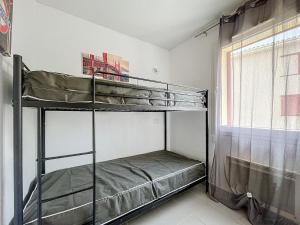 zwei Etagenbetten in einem Zimmer mit Fenster in der Unterkunft 3304-T3 dans une résidence avec piscine in Argelès-sur-Mer