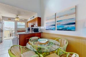 a kitchen with a glass table and chairs at Lani Kai 203 in Gulf Shores
