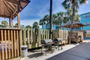 a wooden fence with a grill and a gazebo at Lani Kai 203 in Gulf Shores