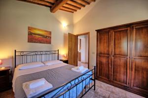 Un dormitorio con una cama y un gran armario de madera. en Villa Picchio by PosarelliVillas, en Volterra