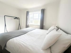 a bedroom with a white bed with a window at Carew Place by Blue Skies Stays in Seaton Carew