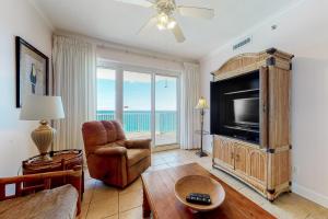 Una sala de estar con televisión, sofá y silla. en Island Royale P 501, en Gulf Shores