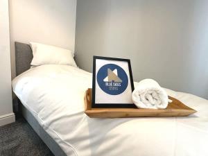 a bed with a wooden tray with a sign on it at Alma House by Blue Skies Stays in Hartlepool