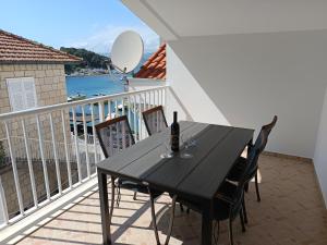 a black table with a bottle of wine on a balcony at Vanda Seafront Superior in Cavtat