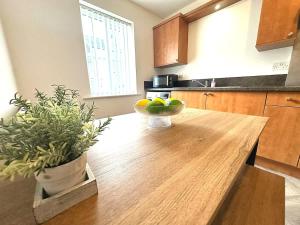 a kitchen with a wooden table with a bowl of fruit on it at Alma House by Blue Skies Stays in Hartlepool