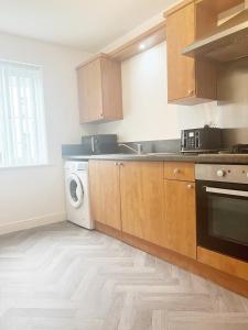 a kitchen with a washer and a sink and a dishwasher at Alma House by Blue Skies Stays in Hartlepool +14 photos