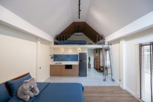 a room with a blue bed and a kitchen at Morya House in Bangkok