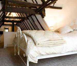 a white bed in a room with wooden ceilings at Cathedral View Guest House in Lincoln