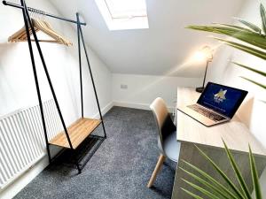 Una habitación con un escritorio con una computadora portátil en un columpio. en Middleton House by Blue Skies Stays, en Hartlepool