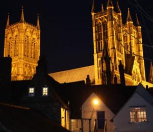 a large cathedral with a clock tower at night at Cathedral View Guest House in Lincoln