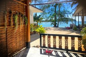 a house with a fence and a view of the ocean at Colibri Beach Resort in Chaloklum