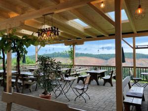 a restaurant with tables and chairs and a view of the mountains at Weingut Giessauf-Nell in Klöch