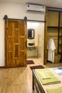 una camera con un'ampia porta in legno e un tavolo di Colibri Beach Resort a Ban Chalok Lam