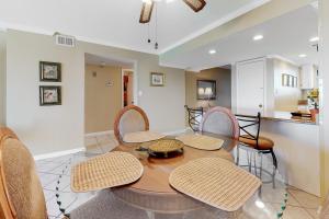 a dining room with a table and chairs and a kitchen at Driftwood Towers 6H in Gulf Shores
