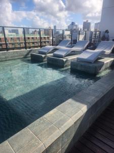 a swimming pool on the roof of a building at Flat João Pessoa Frente Mar - Banheira - Jacuzzi Privativa in João Pessoa