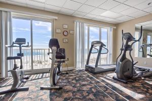Un gimnasio con cintas de correr y bicicletas estáticas en una habitación. en Island Royale P 406, en Gulf Shores