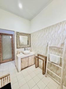 a bathroom with a sink and a tub and a mirror at Villa Ohana 2 BR Family villa with pool in Umalas in Kerobokan