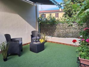 een patio met 2 stoelen, een tafel en bloemen bij Centro Stazione in Treviso