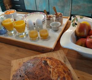 a table with a tray of bread and glasses of orange juice at Spiced Bed&Breakfast in Nykøbing Falster